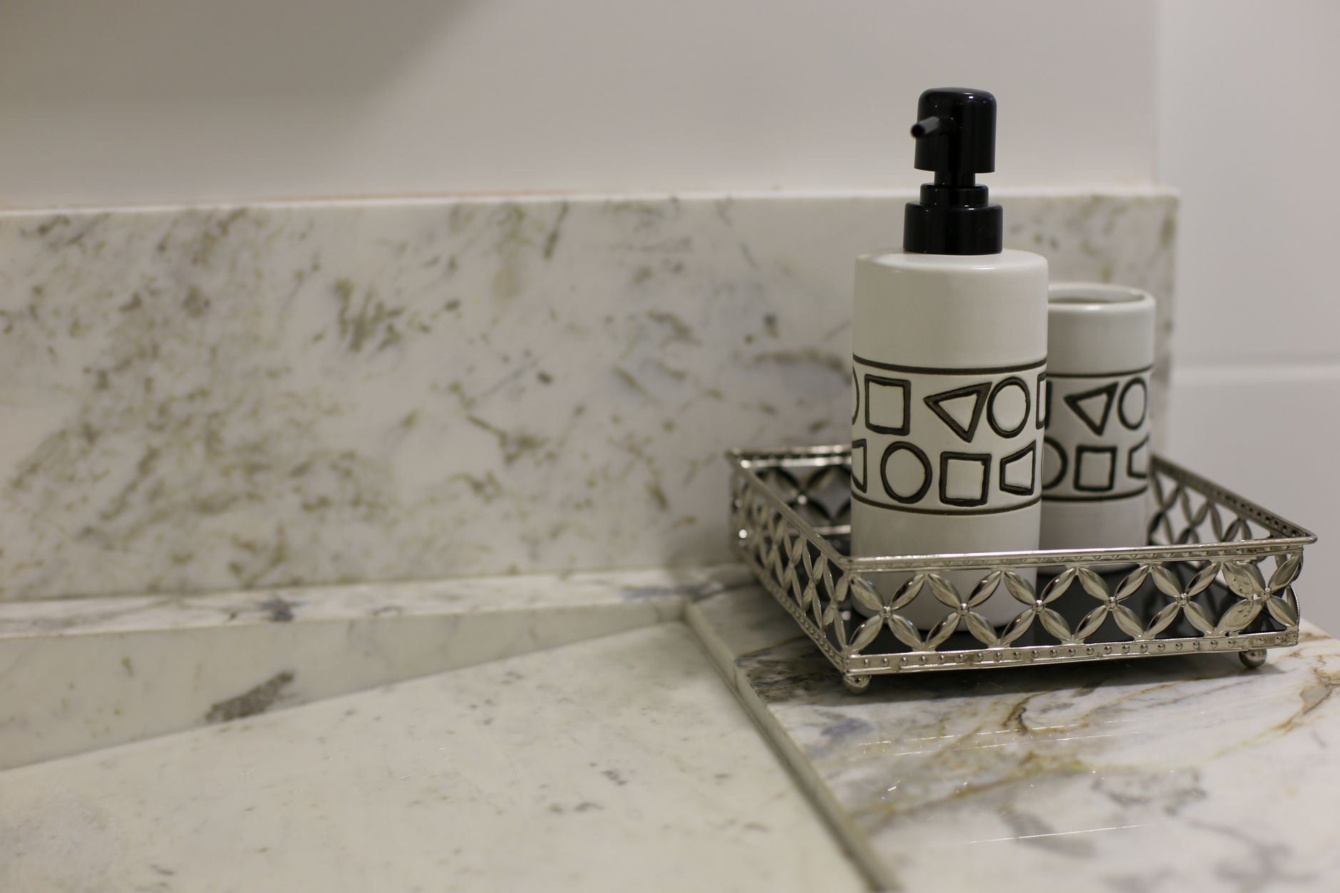 Stylish bathroom setup featuring a marble countertop and a metallic tray with a geometric design soap in Round Rock, TX